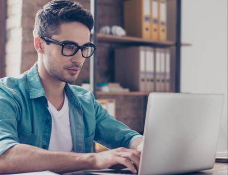 Mann arbeitet am Computer, um die Erstellung eines funktionalen Lebenslaufs zu veranschaulichen