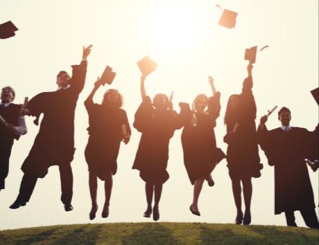 Jeunes diplômés lançant leurs toques en l’air pour illustrer la rubrique Formation d’un CV.