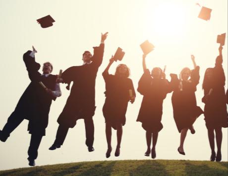 Laureati che lanciano il tocco in aria per illustrare la sezione Formazione del curriculum vitae.