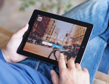 Person using a tablet in their lap with a photo of a city on the screen