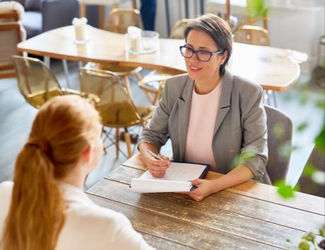 Entretien entre une recruteuse et une candidate autour des informations personnelles figurant sur un CV.