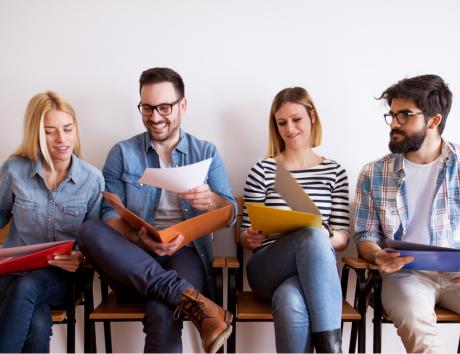 Imagen de cuatro personas revisando unos documentos para ilustrar los adjetivos para currículum