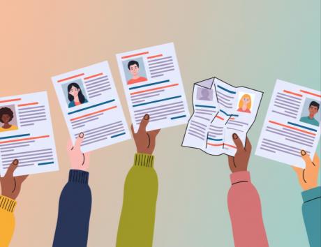 Mann tippt an einem Laptop, auf dem ein Lebenslauf auf dem Bildschirm zu sehen ist.